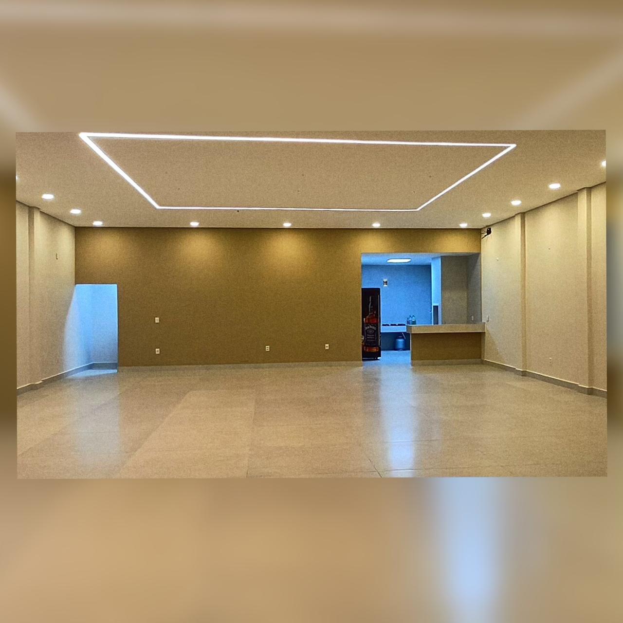 Salão de festas com iluminação linear no teto e piso em porcelanato