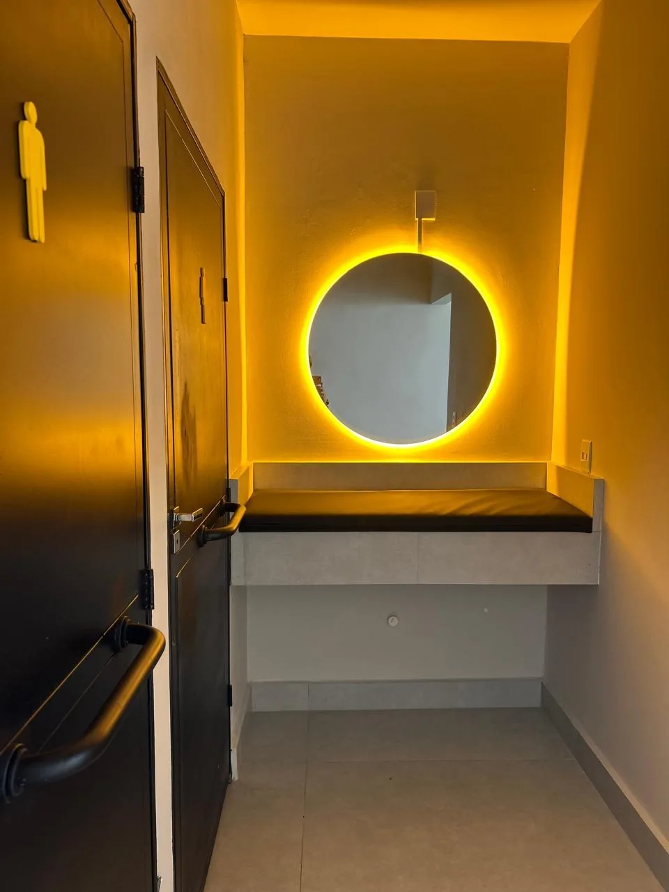 Lavabo do salão de festas com bancada e espelho