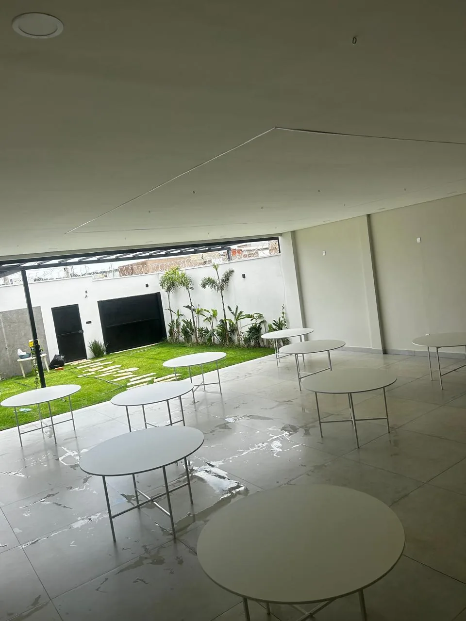 Salão de festas com dez mesas redondas montadas para até 80 convidados