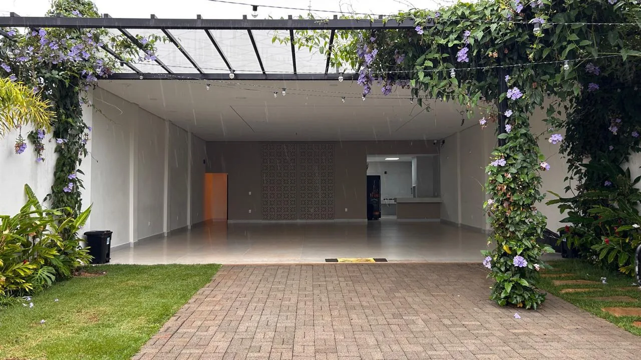 Entrada do salão de festas coberta por pergolado com trepadeiras
